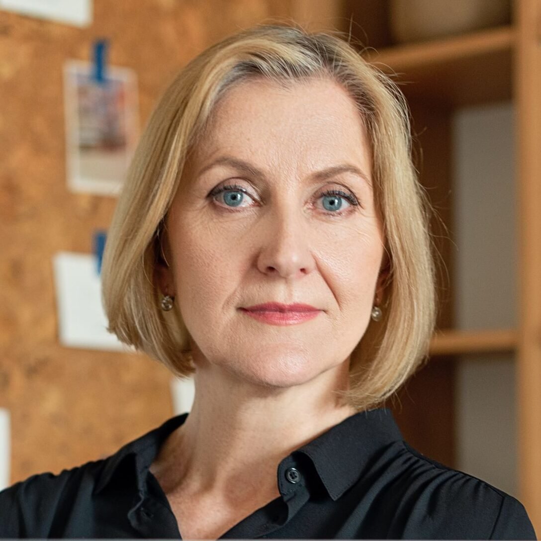 Renata, Professional senior businesswoman sitting at her desk, demonstrating confidence and focus.